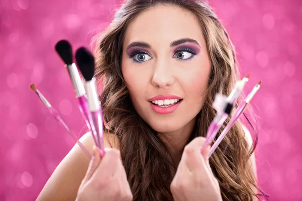 Jonge vrouw kiest make-up borstel — Stockfoto
