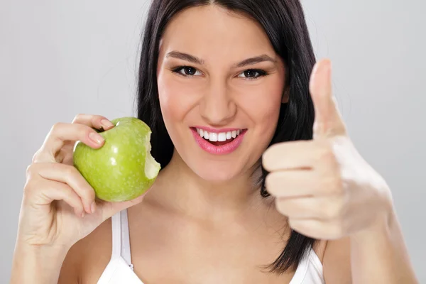 Kvinna med grönt äpple och visar tummen upp — Stockfoto