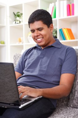 Young man typing on laptop clipart