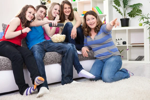 Mladí se smíchem a sledování televize — Stock fotografie