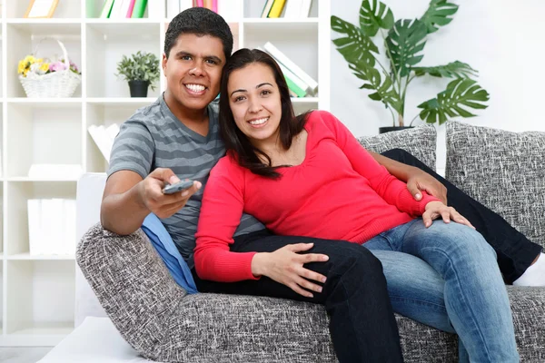 Пара смотрит телевизор в своей гостиной — стоковое фото