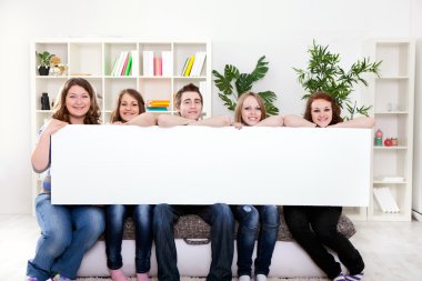 Happy smiling group of friends showing blank placard board clipart