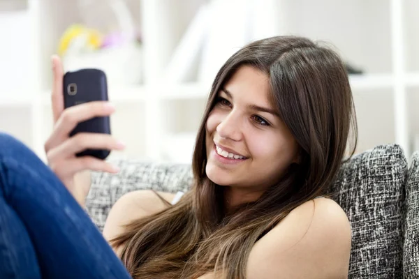 Bedårande flicka läsa meddelande på telefon — Stockfoto