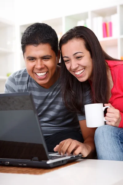 Lyckliga unga paret tittar på en bärbar dator — Stockfoto