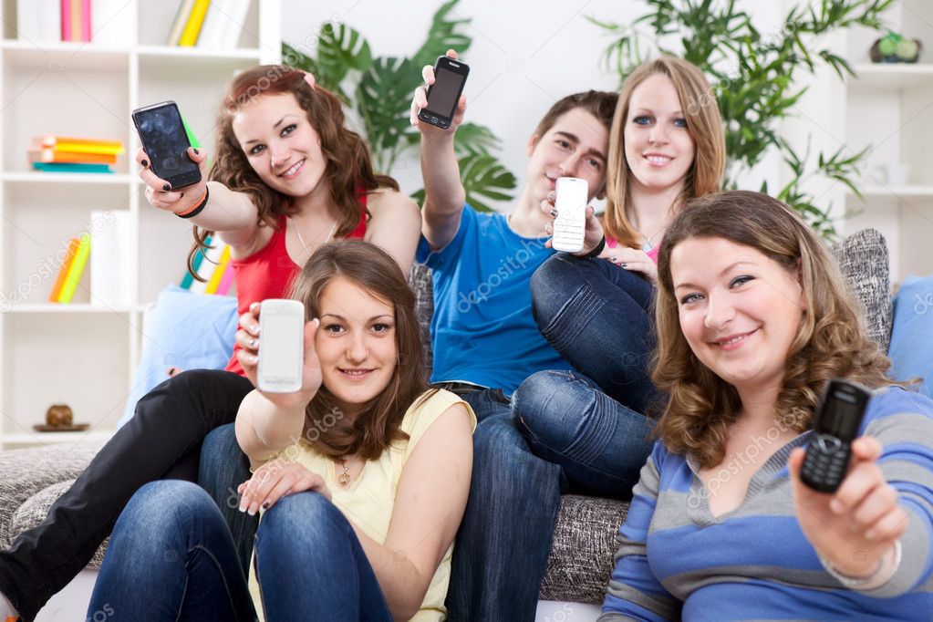 Teenagers showing mobile phones' screen