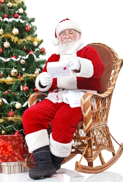 Santa em cadeira de balanço leitura carta — Fotografia de Stock