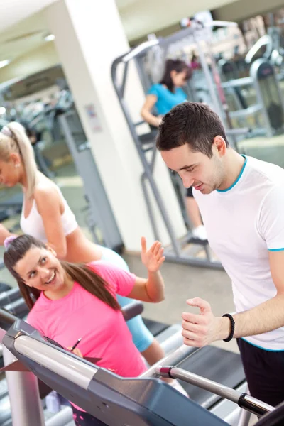 Personal trainer encouraging man using treadmill — Stock Photo, Image