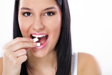 Beautiful girl taking white chewing gum, smiling clipart