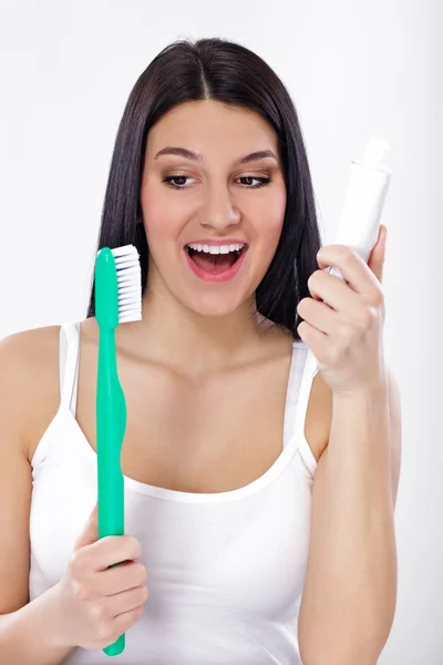 Улыбающаяся девушка с зубной щеткой и зубной пастой — стоковое фото