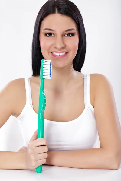 Красива жінка тримає велику зубну щітку — стокове фото