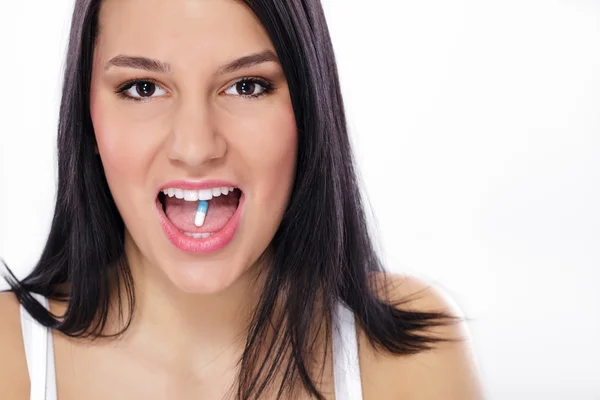 Mulher com pílula nos dentes — Fotografia de Stock