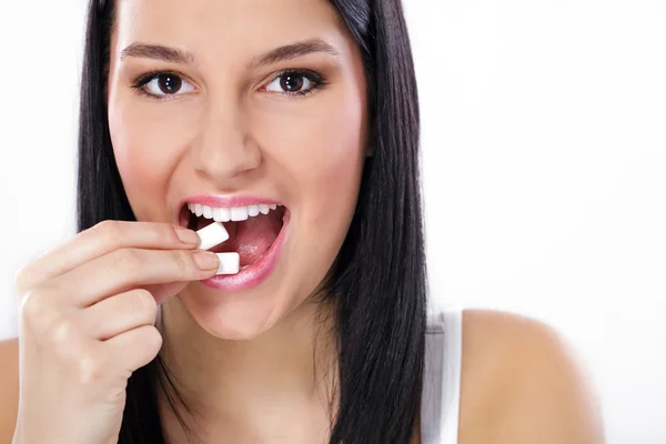 Menina bonita tomando goma de mascar branca, sorrindo — Fotografia de Stock