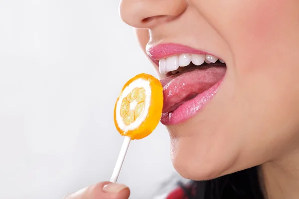 Pretty woman licking candy Stock Image