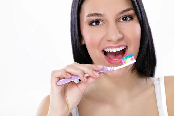 Pretty young woman brushing her teeth — Stock Photo, Image