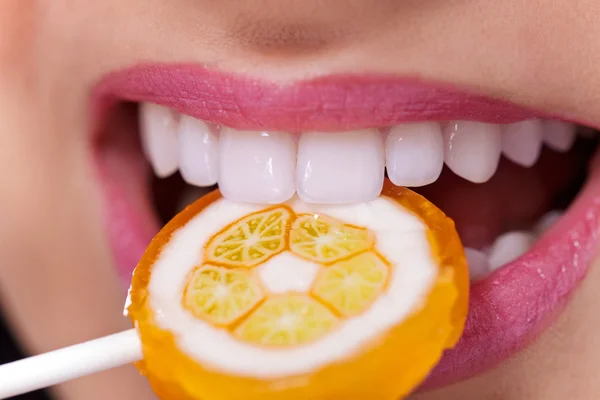 Dentes brancos saudáveis mordendo pirulito — Fotografia de Stock