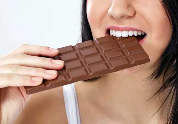 Frau isst Schokolade Stockbild