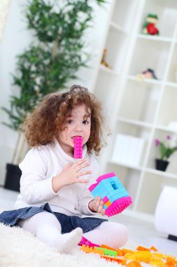 Baby playing with colorful blocks clipart