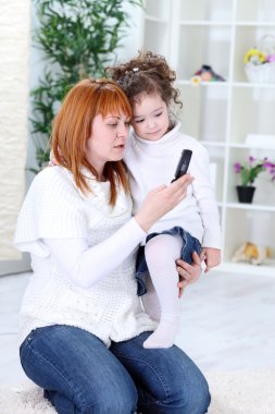 Mother and daughter using cell phone clipart