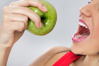 Beautiful young woman eating an apple clipart