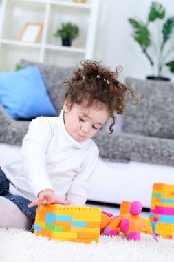 Little girl playing with toy blocks clipart