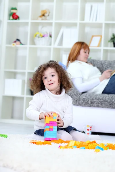 Menina jogando no chão na sala de estar — Fotografia de Stock