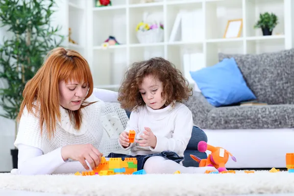 Mother and girl playing on living room floor — Stock Photo, Image