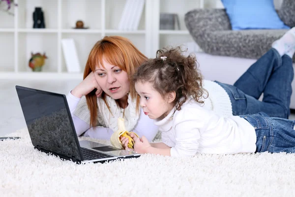 Una madre y una hija mirando un portátil — Foto de Stock