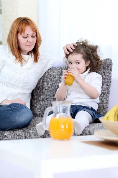 Mother gives daughter juice — Stock Photo, Image