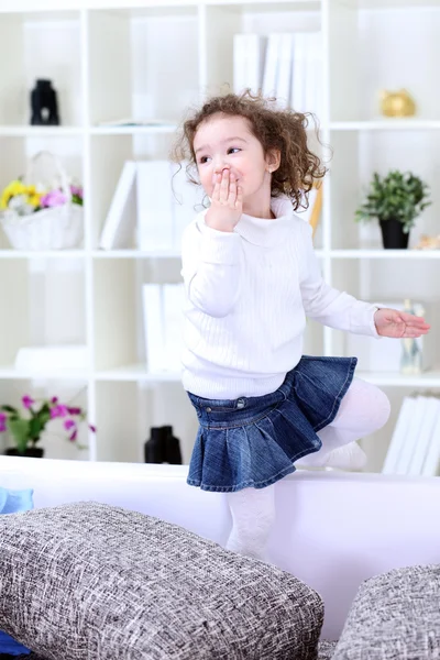 Girl having fun on sofa in living room — Stock Photo, Image