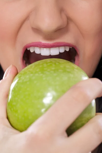 Kvinna äter ett grönt äpple — Stockfoto