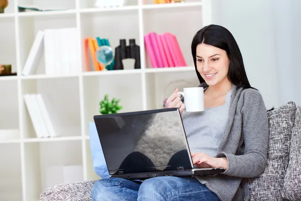 Mulher sorridente com laptop beber café — Fotografia de Stock
