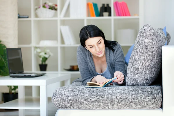 Mujer Reading a Book on Sofa — Foto de Stock