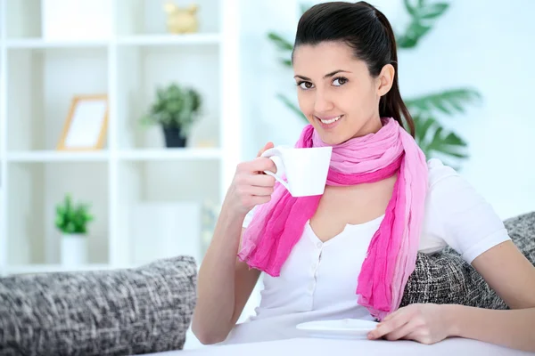 Beauty lady sitting on sofa and drinking coffee — Stock Photo, Image