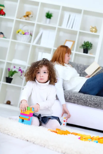 Child playing with cubes at home with mother on sofa — Stock Photo, Image