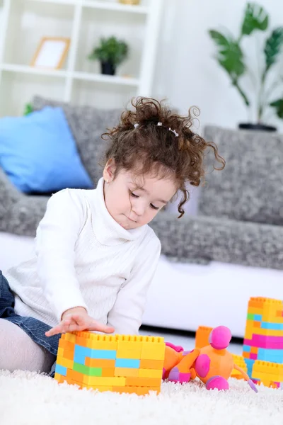 Маленькая девочка играет с игрушечными блоками — стоковое фото