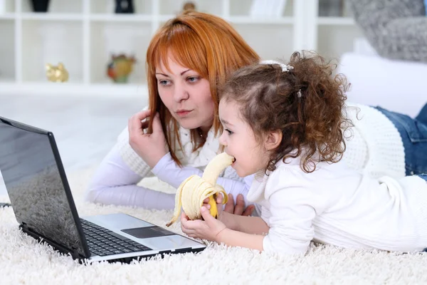 Mãe e filha olhando para um laptop — Fotografia de Stock