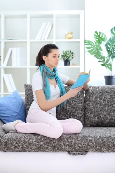 Mulher lendo um livro em sua sala de estar — Fotografia de Stock