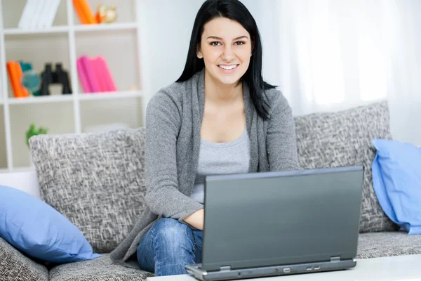 Young girl with laptop computer, sitting in living room Stock Image