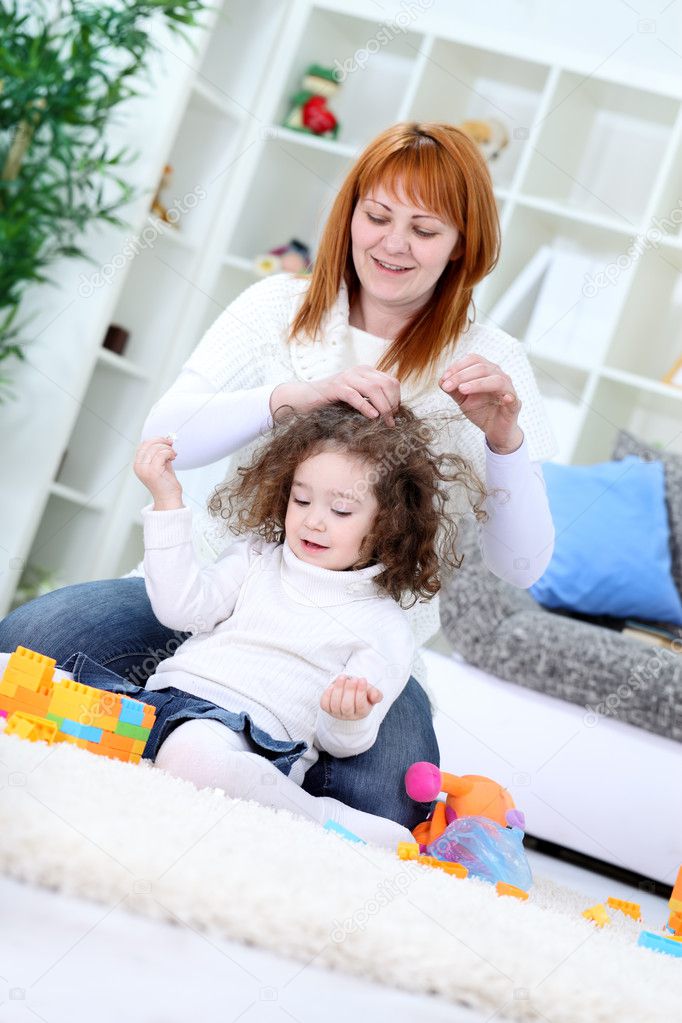 Young woman brushing her daughter's hair