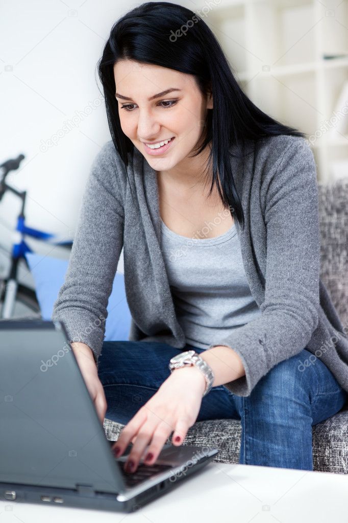 Young woman smiling while using laptop