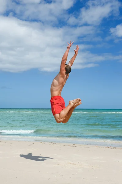 Muž skákání na pláži — Stock fotografie