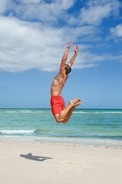 Homme sautant sur la plage — Photo