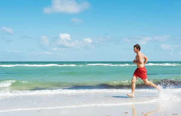 Muž běží podél pobřeží — Stock fotografie