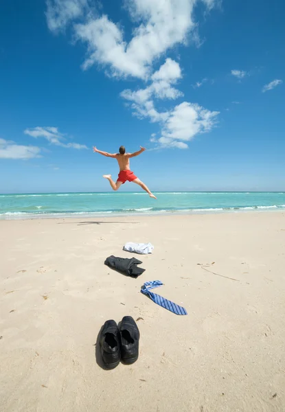Businessman jumping on the beach — Stock Photo, Image