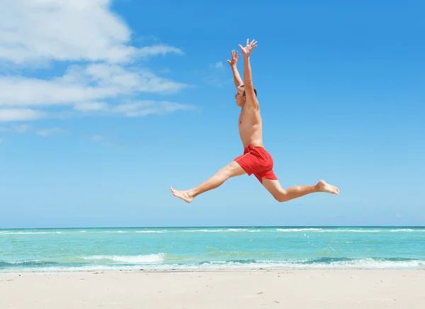 男人在海滩上跳跃 — 图库照片