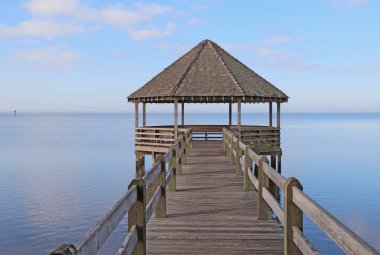 Gazebo and dock over calm sound waters clipart