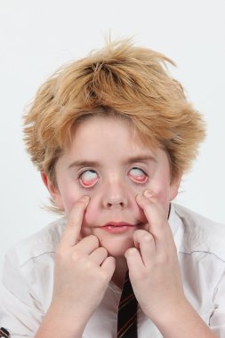 Cute little boy posing for camera on white