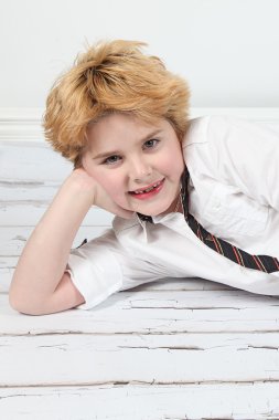 Cute little boy posing for camera on white