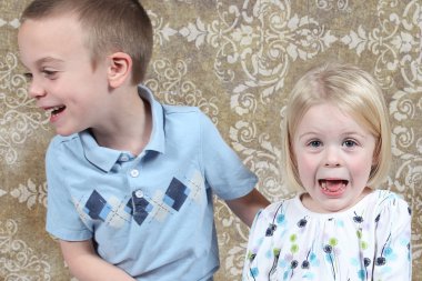 Adorable little brother and Sister having fun on studio background clipart