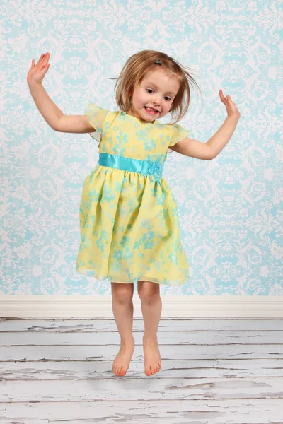 Очаровательная маленькая девочка прыгает в воздух в студии — стоковое фото